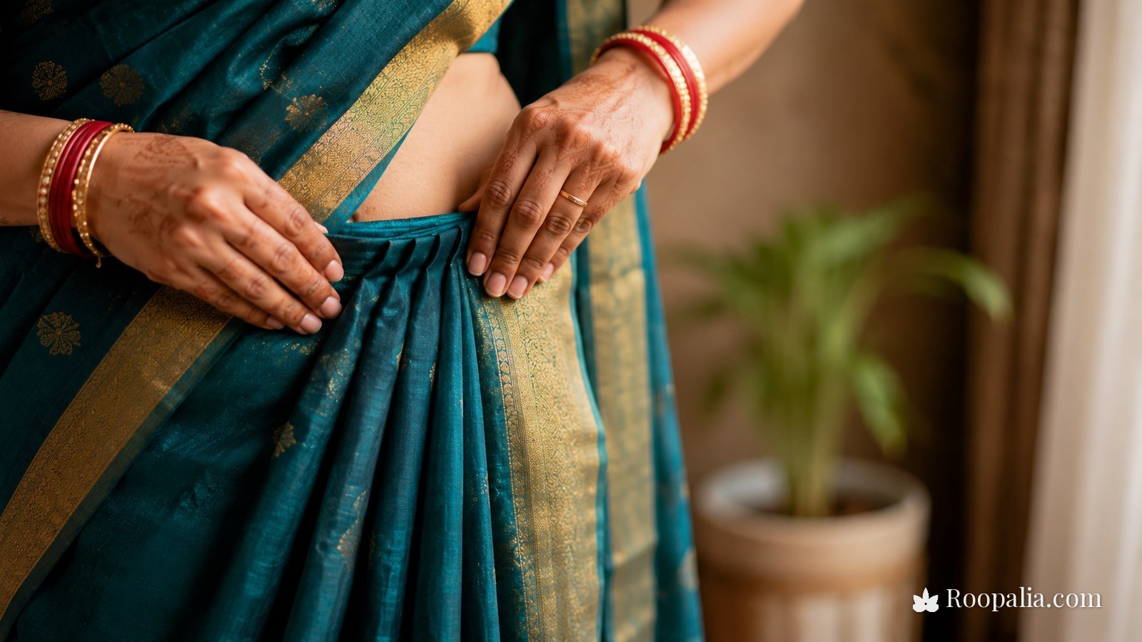 Making saree pleats — hands gathering even pleats at the waist and tucking them into the petticoat