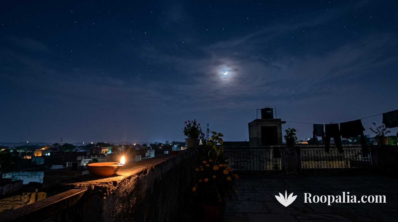 A crescent moon behind clouds above a rooftop parapet with a single lit lamp — AI-generated image (Roopalia)