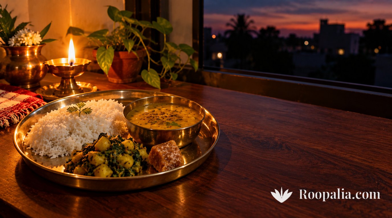 A single simple vegetarian meal on a brass thali beside a window after sunset &mdash; plain rice, a bowl of dal, one vegetable and a piece of jaggery, lit mainly by an oil lamp, deep indigo sky outside &mdash; AI-generated image (Roopalia)